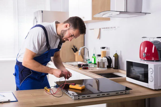 Technician testing a residential electric cooktop with diagnostic tools