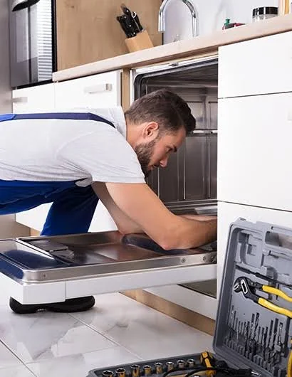 Technician inspecting the interior of a residential dishwasher