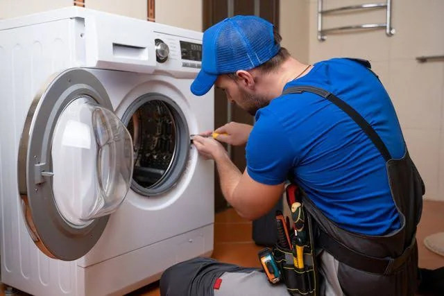 Technician inspecting a residential laundry appliance