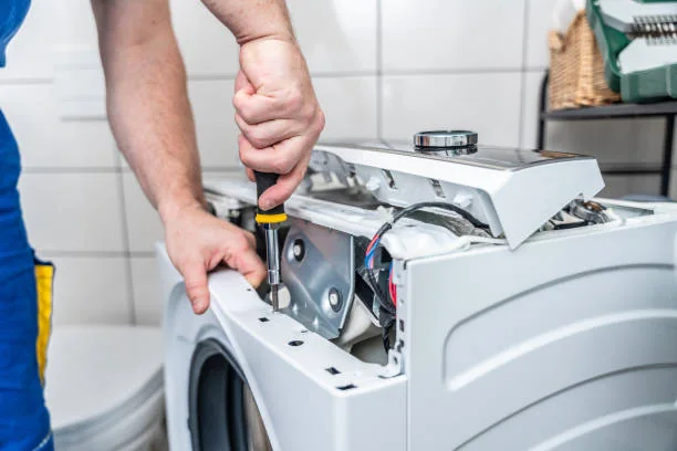 Close-up of an appliance technician working with tools and internal components