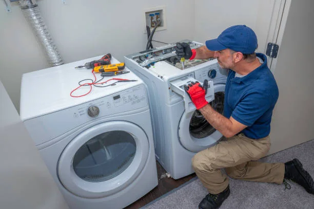 Technician evaluating a washer and dryer during an appliance service visit