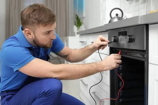 Technician testing the controls of a residential cooking appliance