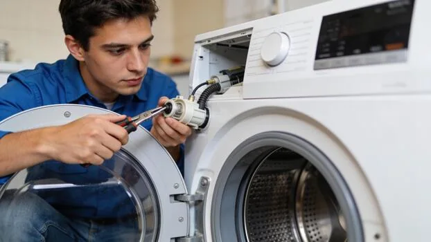 Appliance technician repairing a front-loading washing machine